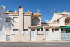 a building with white doors and a fence at Hygee in San Javier
