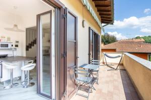 a balcony with chairs and a kitchen in a house at Rocca Lake House in Angera