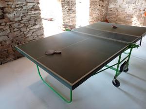 a ping pong table with two tennis rackets on it at Gîte des Bruyeres in Beynat