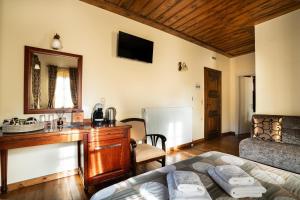 a bedroom with a bed and a desk with a mirror at Guest House Amadryades in Karpenisi