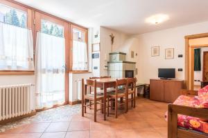 a kitchen with a table and chairs in a room at Maso Noce Ovest in Mezzana +15 photos