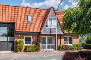 a brick house with an orange roof at Die Alter Schwede Wohnung 3 in Vechta