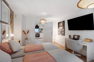 a bedroom with a bed and a desk and a television at Modern und gemütlich- in Teningen in Teningen +12 photos