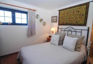 a bedroom with a bed with pillows and a window at Finca el Volcan in Mácher +12 photos