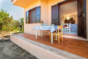 a patio with a table and chairs on a house at Casetta paradiso in Costa Paradiso