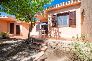 a house with a tree and stairs in front of it at Casetta paradiso in Costa Paradiso +14 photos