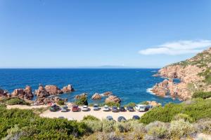 a group of cars parked on a beach next to the ocean at Casetta paradiso in Costa Paradiso
