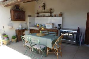 a kitchen with a table with chairs and a stove at Chambres D'hôtes La Buissonnière in Théziers +18 photos