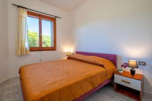 a bedroom with a orange bed and a window at Casetta paradiso in Costa Paradiso