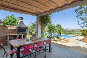 a patio with a table and chairs and a pool at Finca encanto in Arcos de la Frontera