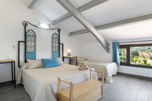 two beds in a room with a window at Finca encanto in Arcos de la Frontera +37 photos