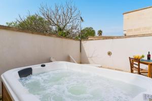 a bath tub sitting on top of a patio at Corte Cochlea Lu Sciardinu Suite in Cannole