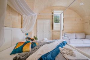 a large bed in a room with a couch at Corte Cochlea Lu Sciardinu Suite in Cannole