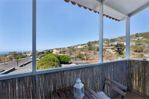 a balcony with a bench and a view of a street at El Almendro in Puntagorda