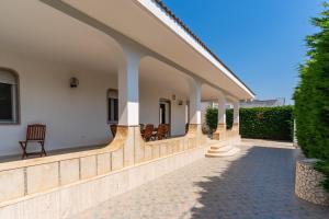 a porch of a house with chairs on it at Di Chiara in Torre Lapillo