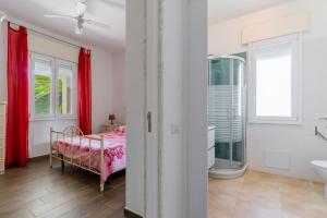 a bedroom with a bed and a shower and a sink at Di Chiara in Torre Lapillo