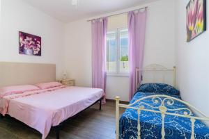 a bedroom with two beds and a window at Di Chiara in Torre Lapillo