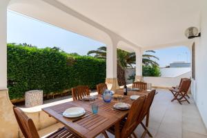 a dining room with a wooden table and chairs at Di Chiara in Torre Lapillo