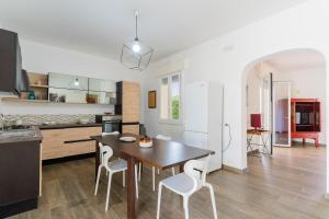 a kitchen and dining room with a table and chairs at Di Chiara in Torre Lapillo +22 photos