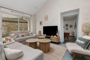 a living room with two couches and a tv at Maison et Bonheur in Batz-sur-Mer