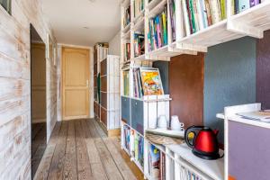 a hallway with bookshelves filled with books at La chambre L'ile de Tom in Lège-Cap-Ferret