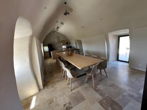 a dining room with a wooden table and chairs at Domaine avec vue cirque du Levancou in Saint-Georges-de-Luzençon