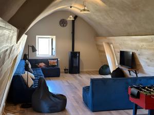 a living room with a blue couch and a tv at Domaine avec vue cirque du Levancou in Saint-Georges-de-Luzençon
