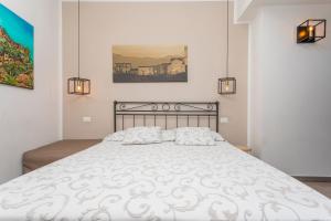 a bedroom with a large white bed with two lights at Pentefur Suite Savoca in Savoca
