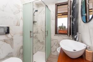 a bathroom with a sink and a glass shower at Pentefur Suite Savoca in Savoca