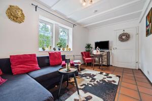 a living room with a blue couch and red pillows at Wie Bei Muddi in Lübbecke