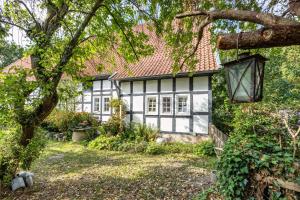 a white and black house with a tree at Wie Bei Muddi in Lübbecke