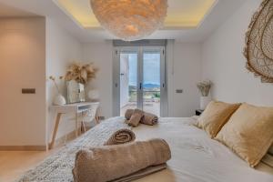 a bedroom with a large bed with a chandelier at Avalon in Benahavís +22 photos