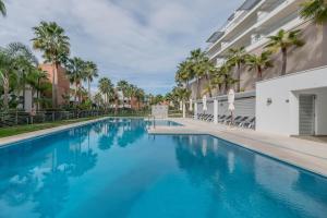 a swimming pool with blue water in front of a building at Avalon in Benahavís