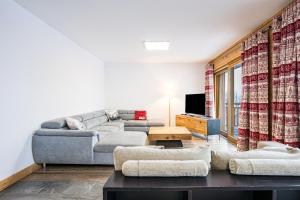 a living room with a couch and a tv at Chalet Salt Lake in La Toussuire
