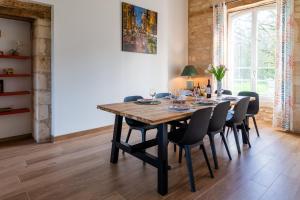 a dining room with a wooden table and chairs at Gîte de l'Abbaye chambre triple in Rollainville