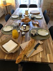 a wooden table with plates and food on it at Gîte de l'Abbaye chambre triple in Rollainville +5 photos