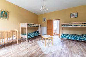 a room with three bunk beds and a table at Gîte de l'Abbaye chambre triple in Rollainville