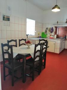 a kitchen with a table and chairs with a bowl of fruit on it at Casa do Rossio in Fajazinha