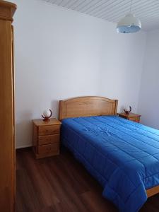a bedroom with a blue bed and two night stands at Casa do Rossio in Fajazinha