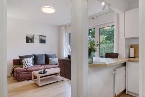 a kitchen and a living room with a couch at Schwarzwald-Kitz mit Pool und Sauna in Lenzkirch