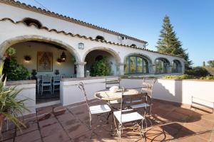 a patio with a table and chairs next to a building at Casa Espigol in El Bruc