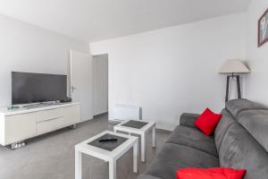 a living room with a couch and a flat screen tv at Entre plage, forêt et villages in Mimizan