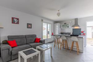 a living room with a couch and a kitchen at Entre plage, forêt et villages in Mimizan
