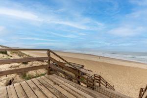 a wooden staircase leading down to the beach at Entre plage, forêt et villages in Mimizan