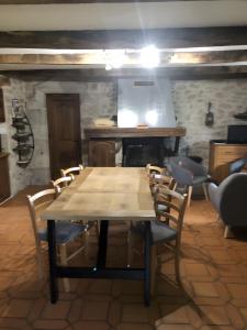 a wooden table and chairs in a room with a kitchen at Gîte Du Cayrou in Bournazel
