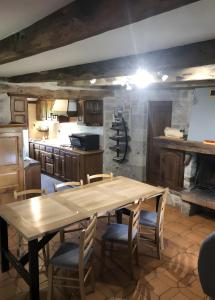 a large kitchen with a wooden table and chairs at Gîte Du Cayrou in Bournazel