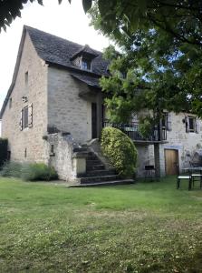 an old stone house with a grass yard at Gîte Du Cayrou in Bournazel