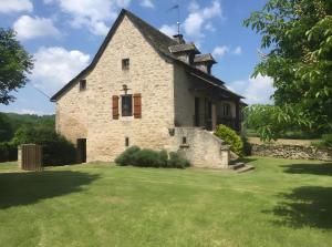 an old stone house with a grass yard at Gîte Du Cayrou in Bournazel +12 photos
