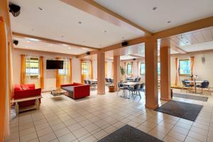 a large room with a lobby with tables and chairs at Hotel Neue Krone - Markt Erlbach in Markt Erlbach