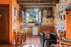 a kitchen with orange walls and a white refrigerator at Nogueira in Vega de Logares